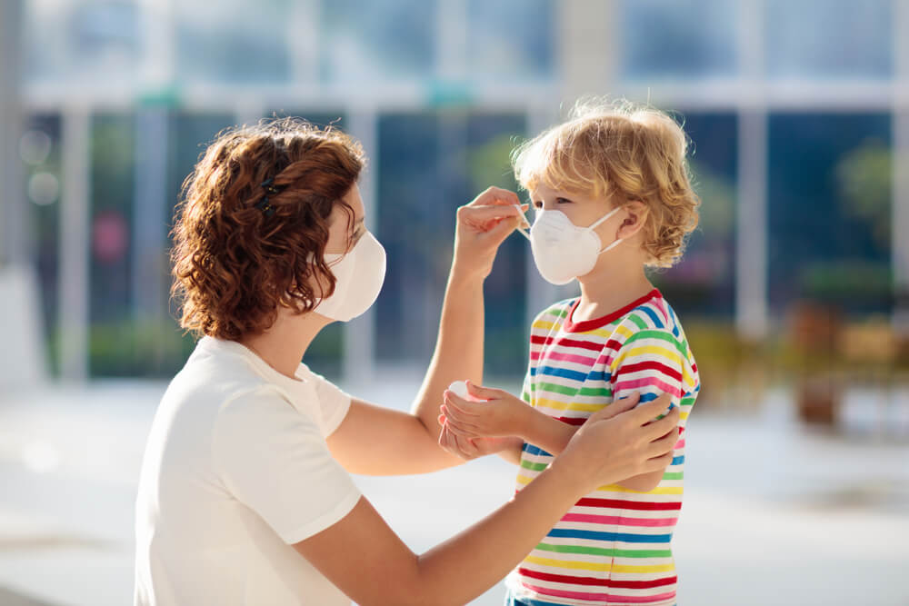 Family with kids in face mask in shopping mall or airport. Mother and child wear facemask during coronavirus and flu outbreak. Virus and illness protection.