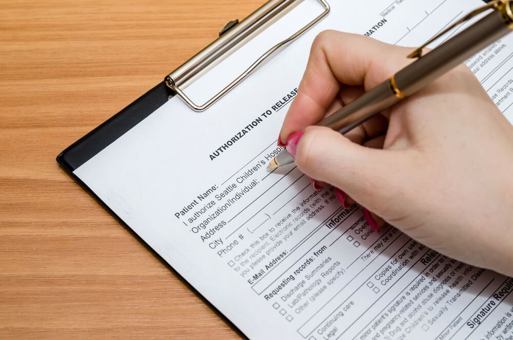 Close up of hand with a pen filling out a medical form