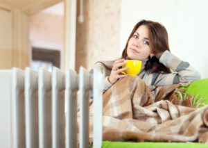 Woman sitting on a couch with a blanket and coffee mug