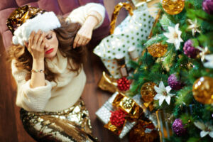 woman sitting next to christmas tree 