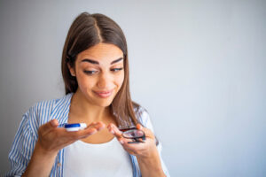 girl deciding between contacts and glasses