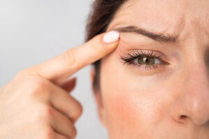 woman point at her upper eyelid