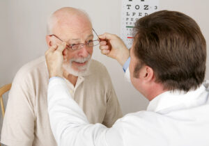 eye doctor putting eyeglasses on patient 